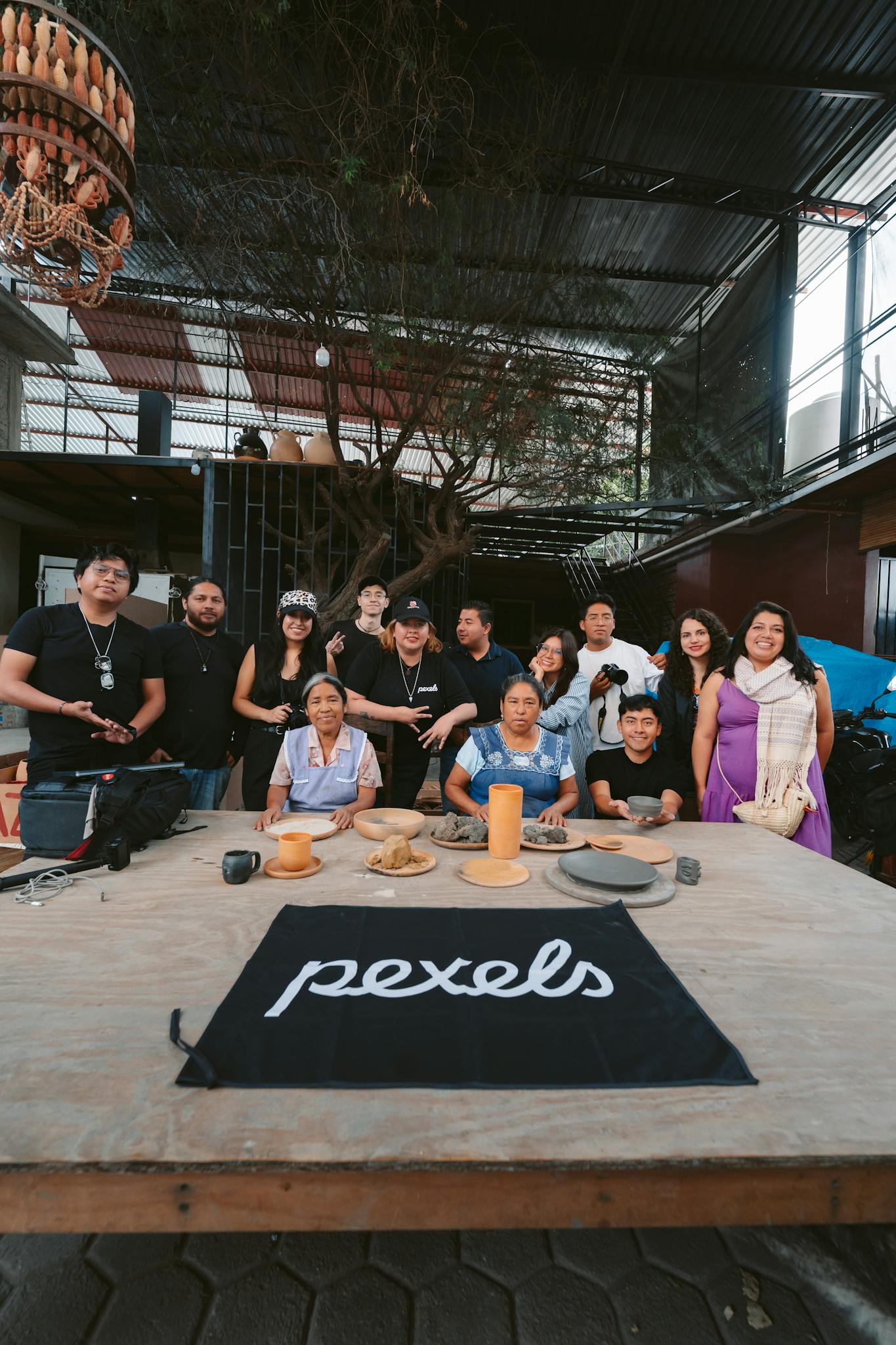 A diverse group of people gathered in an artisan workshop in Oaxaca, Mexico.
